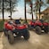 Two ATVs parked next to a building near a beach